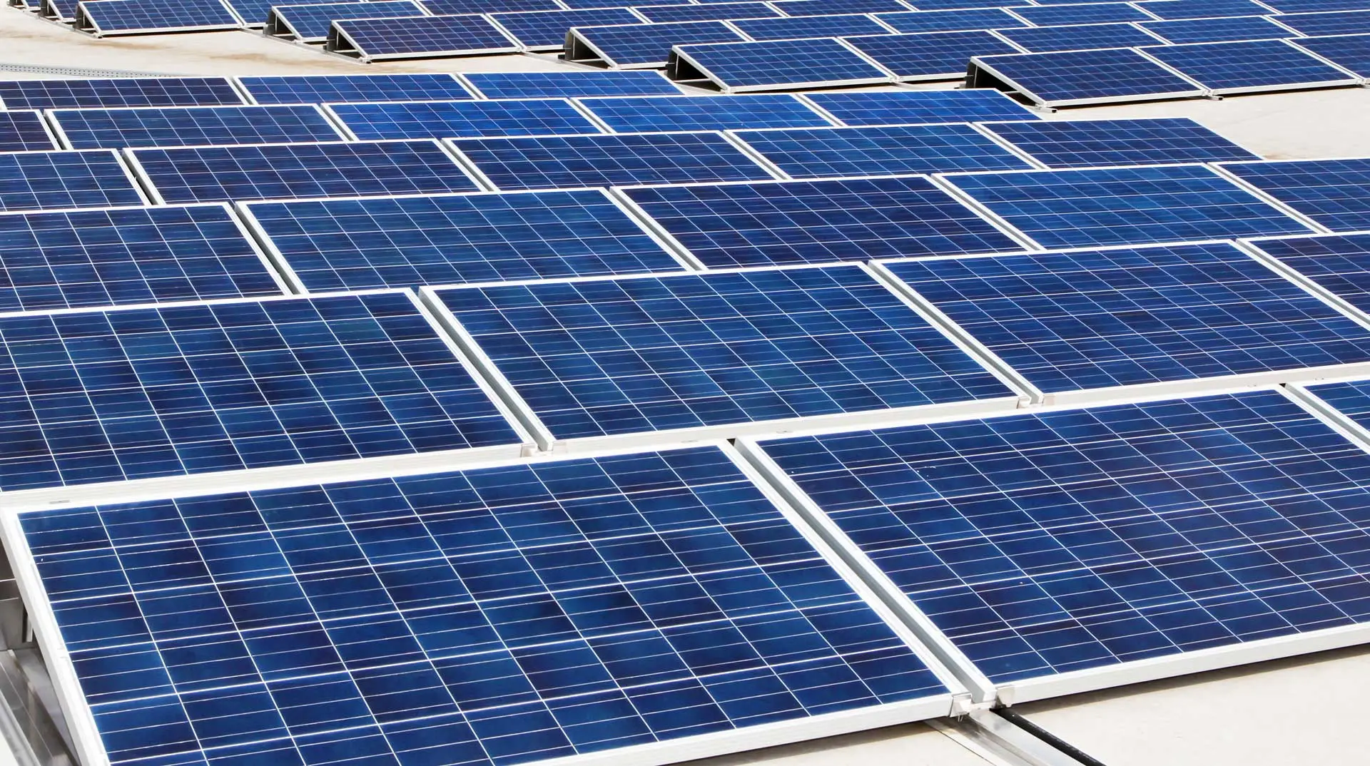 Rows of blue solar panels on a commercial roof