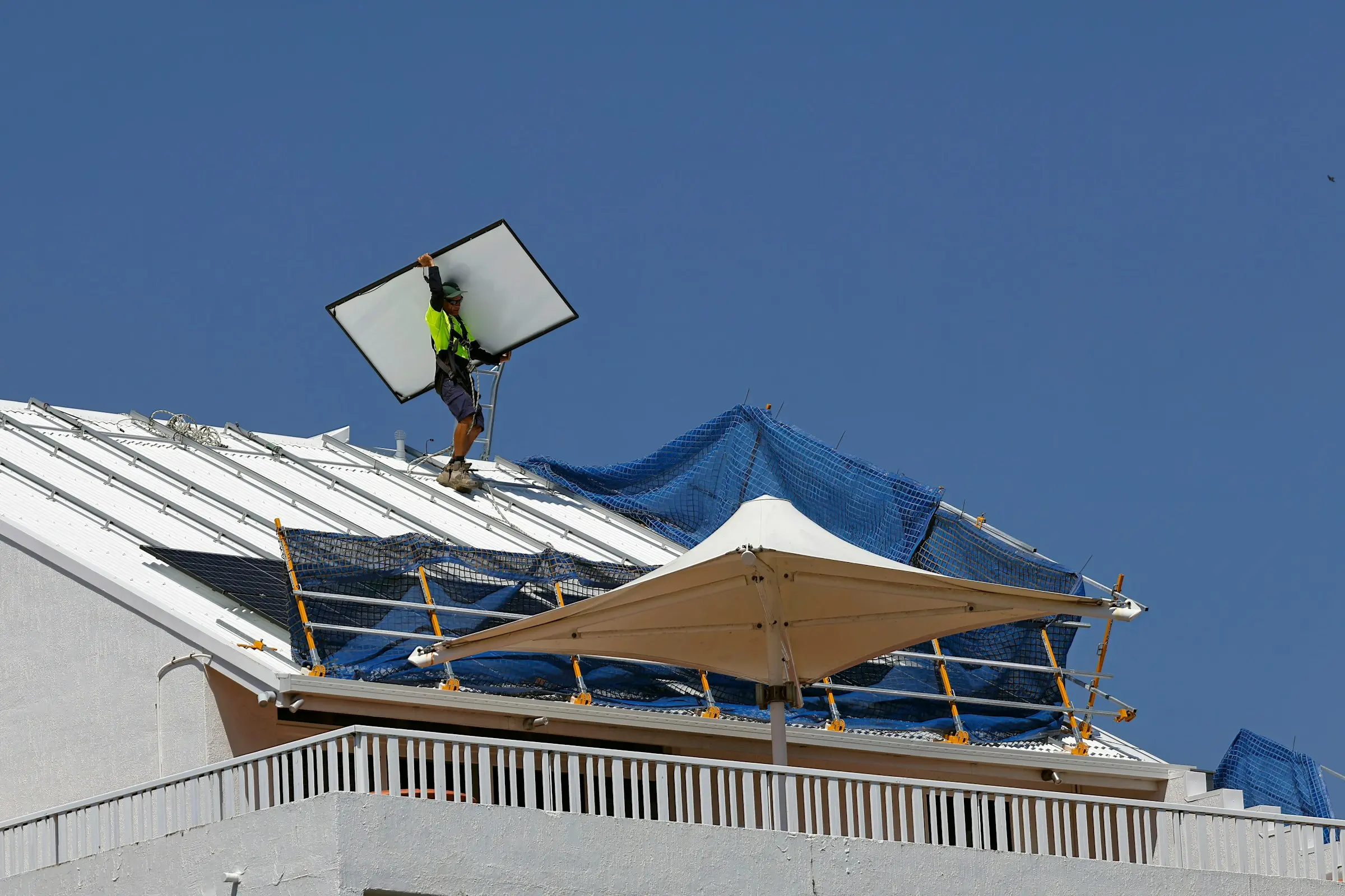 Installer working on solar panels on a roof