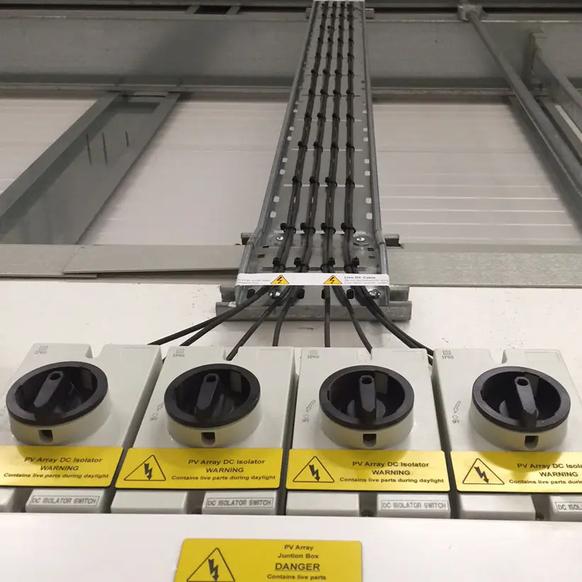 Row of DC isolator switches below a solar array
