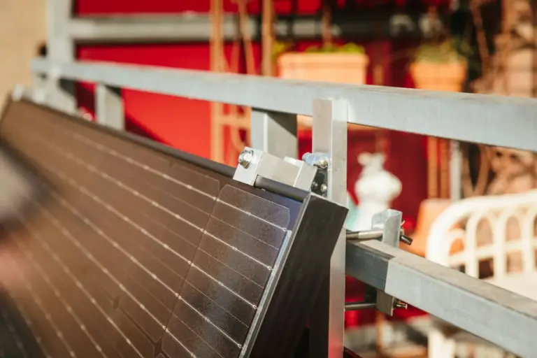 Small solar panel being fitted to a balcony frame